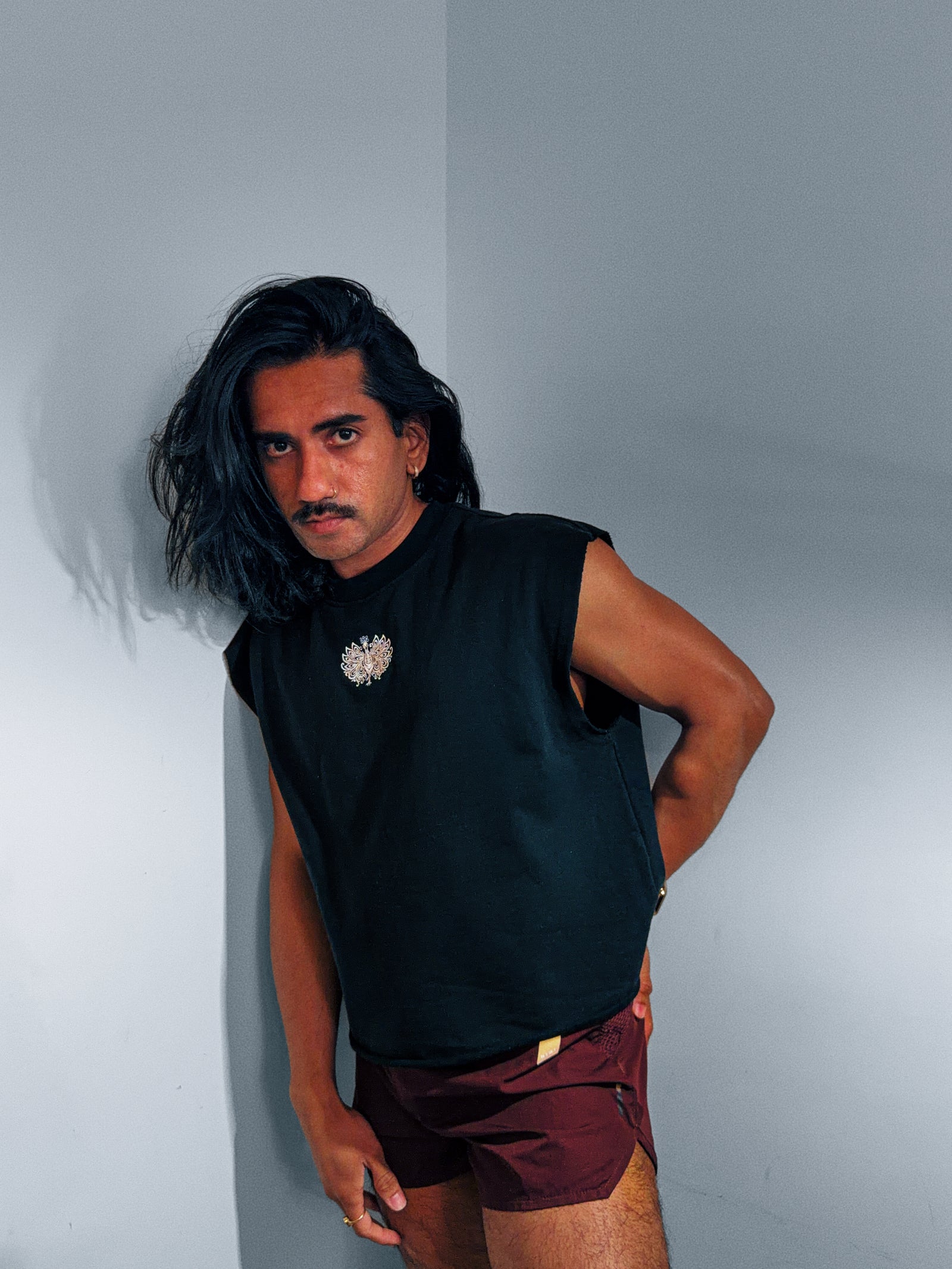 Aarvein campaign: a black sleeveless top with an embroidered peacock